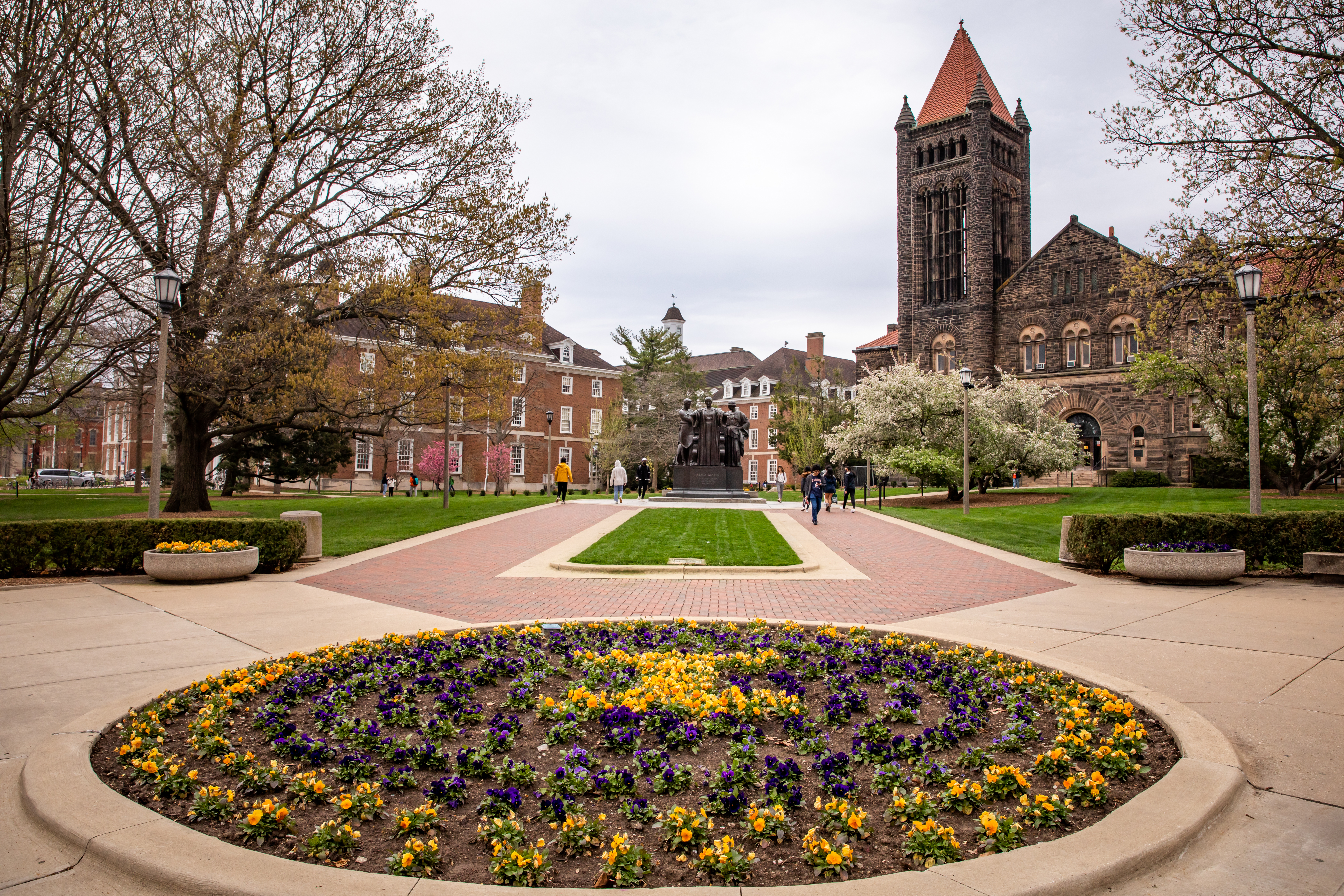 Alma Mater statue and flowers in the spring